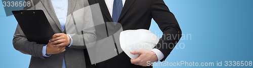 Image of businesspeople with clipboard and helmet