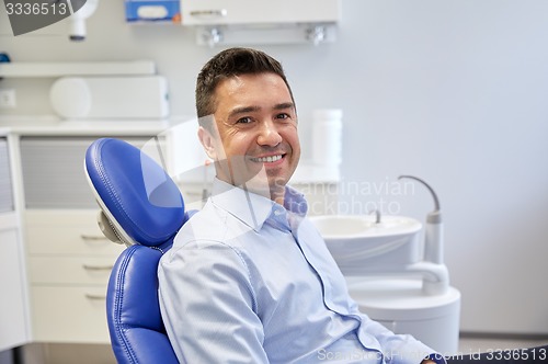 Image of happy male patient sitting on dental chair