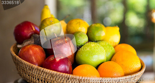 Image of basket of fresh ripe juicy fruits at kitchen