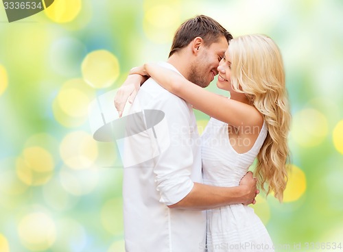 Image of happy couple hugging over green lights background