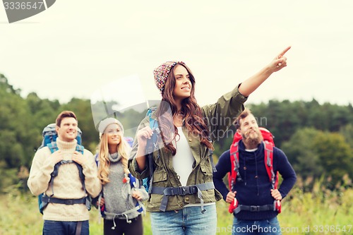 Image of smiling hikers with backpacks pointing finger