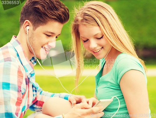 Image of smiling couple with smartphone and earphones