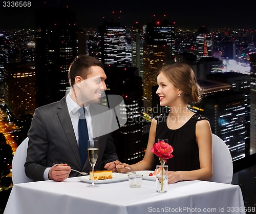 Image of smiling couple eating dessert at restaurant