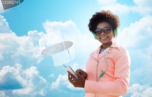 Image of happy young woman with smartphone and headphones