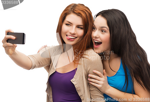 Image of two smiling teenagers with smartphone