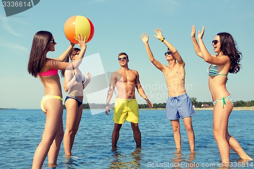 Image of smiling friends in sunglasses on summer beach