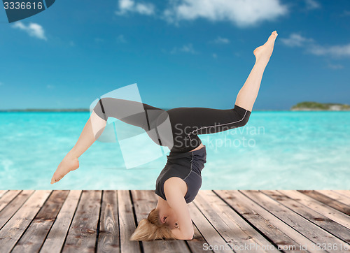 Image of happy young woman doing yoga exercise