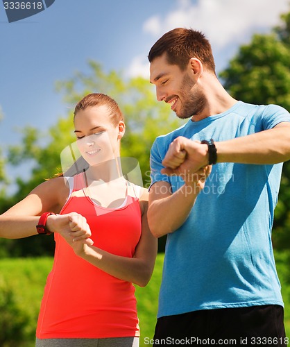 Image of smiling people with heart rate watches outdoors