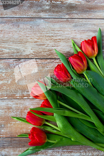Image of close up of red tulips on wooden background