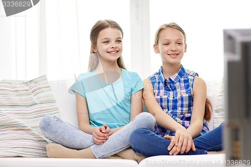 Image of two happy little girls watching tv at home