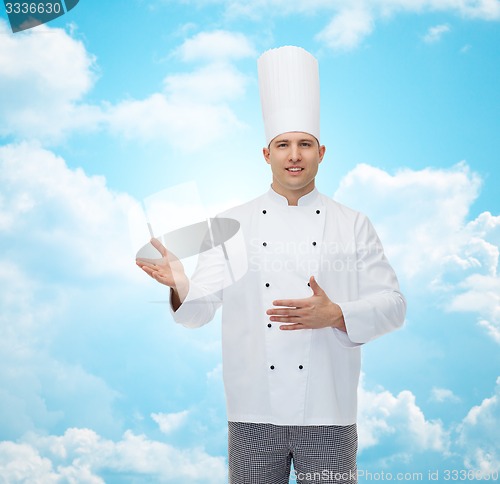 Image of happy male chef cook inviting