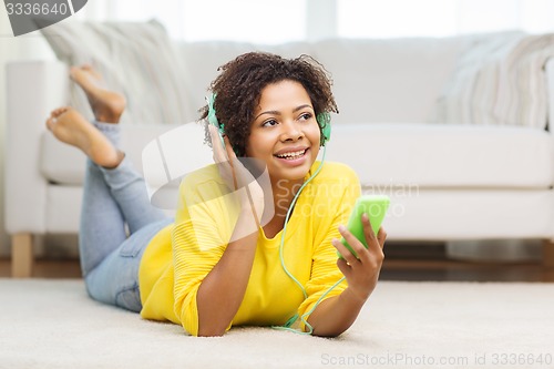Image of happy african woman with smartphone and headphones