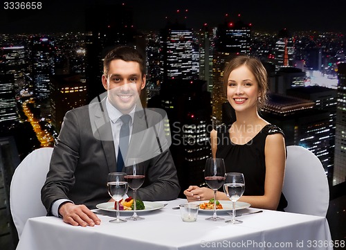 Image of smiling couple eating main course at restaurant