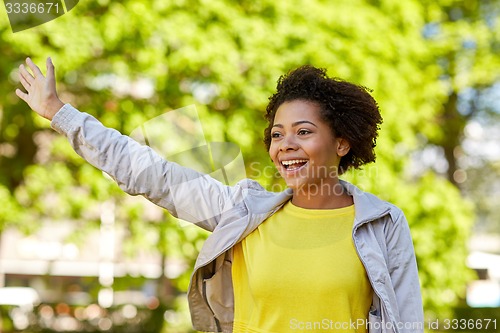 Image of happy african american young woman in summer park