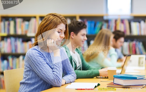 Image of happy student girl reading books in library