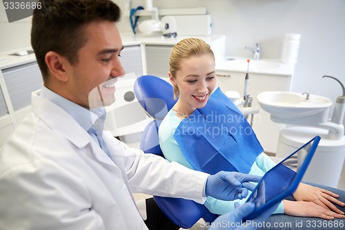 Image of male dentist with tablet pc and woman patient