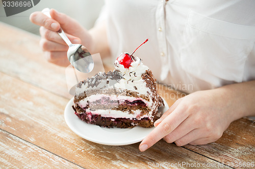 Image of close up of woman eating chocolate cherry cake