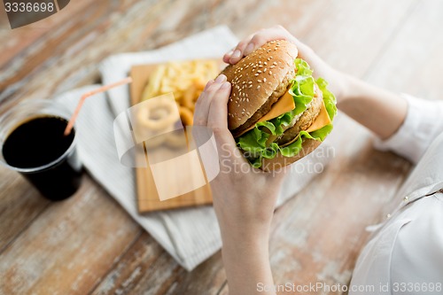 Image of close up of woman hands holding hamburger