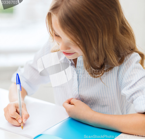 Image of student girl writing in notebook at school