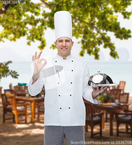 Image of happy male chef cook with cloche showing ok sign