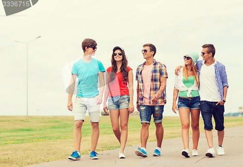 Image of group of smiling teenagers walking outdoors