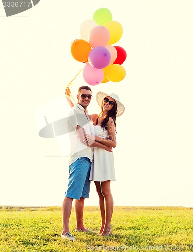 Image of smiling couple with air balloons outdoors