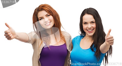 Image of two smiling girls showing thumbs up