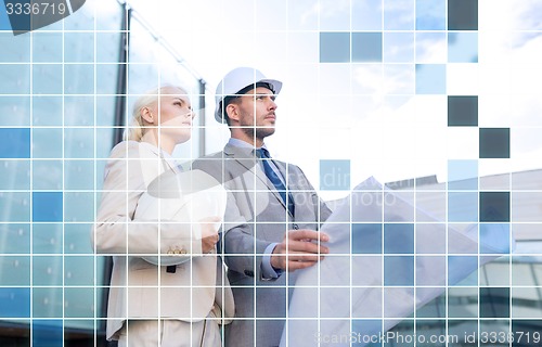 Image of business people in helmets with blueprint