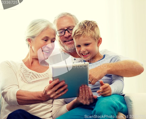 Image of smiling family with tablet pc at home