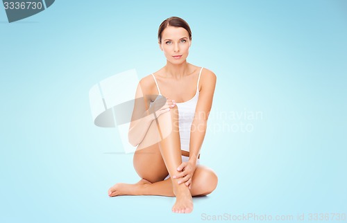 Image of beautiful woman in cotton underwear touching legs