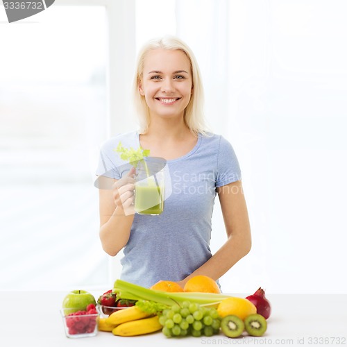 Image of smiling woman drinking juice or shake at home