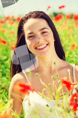 Image of smiling young woman on poppy field