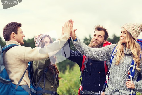 Image of group of smiling friends with backpacks hiking