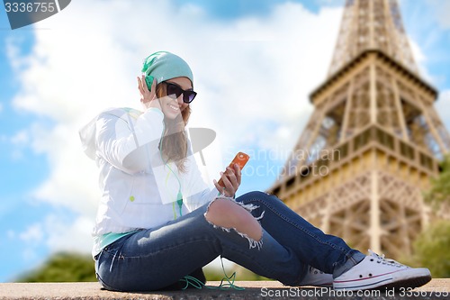 Image of happy young woman with smartphone and headphones