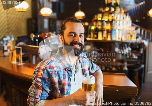 Image of happy man drinking beer at bar or pub