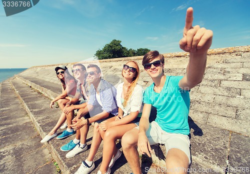 Image of group of smiling friends sitting on city street