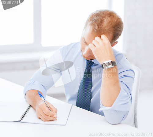 Image of businessman with notebook and computer