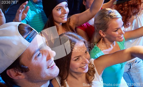 Image of smiling friends at concert in club