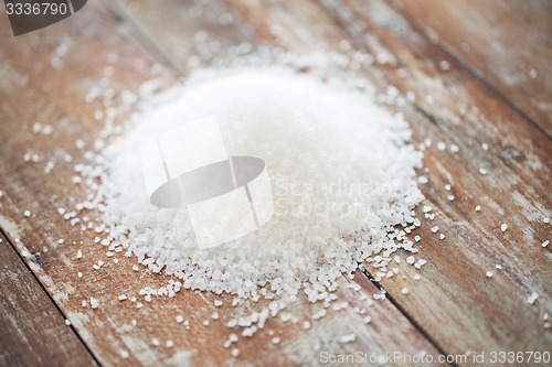 Image of close up of white salt heap on wooden table