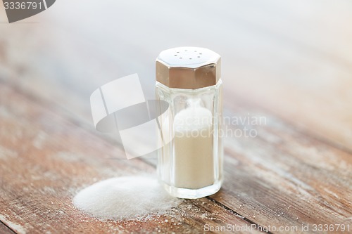 Image of close up of white salt cellar on wooden table