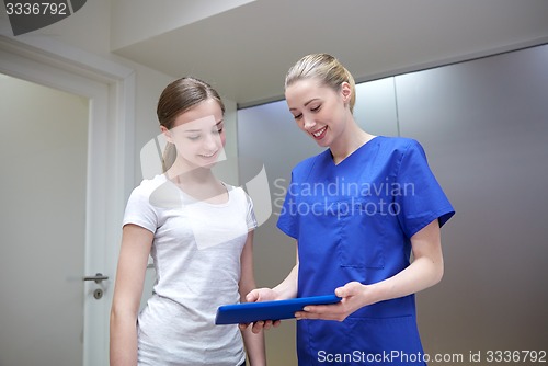 Image of smiling nurse with tablet pc and girl at hospital