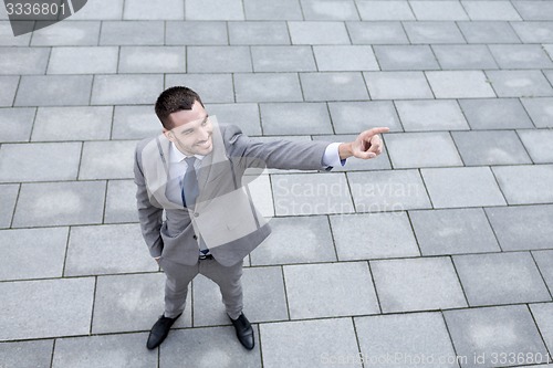 Image of young smiling businessman outdoors from top