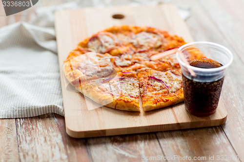Image of close up of pizza with coca cola on table