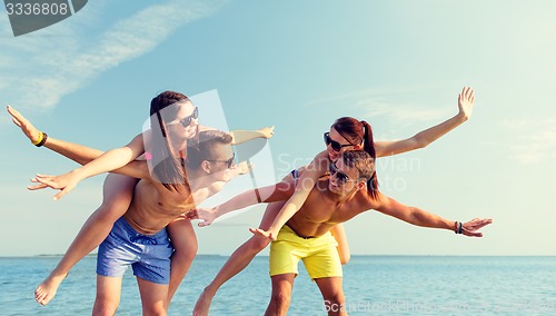 Image of smiling friends having fun on summer beach