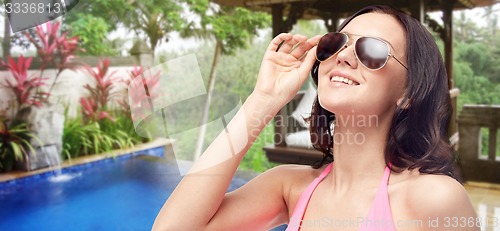 Image of happy woman in sunglasses and swimsuit