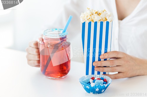 Image of woman with popcorn and drink in glass mason jar