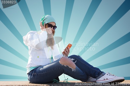 Image of happy young woman with smartphone and headphones