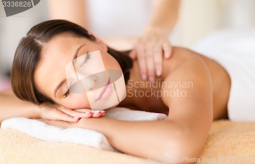 Image of beautiful woman in spa salon getting massage