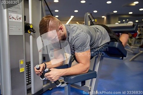 Image of man flexing leg muscles on gym machine