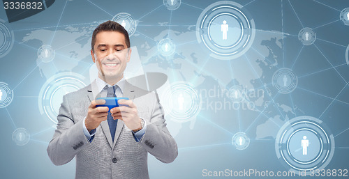 Image of happy businessman texting message on smartphone